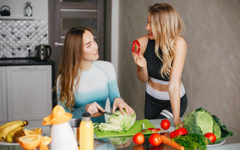 Zwei Frauen in der Küche mit Gemüse